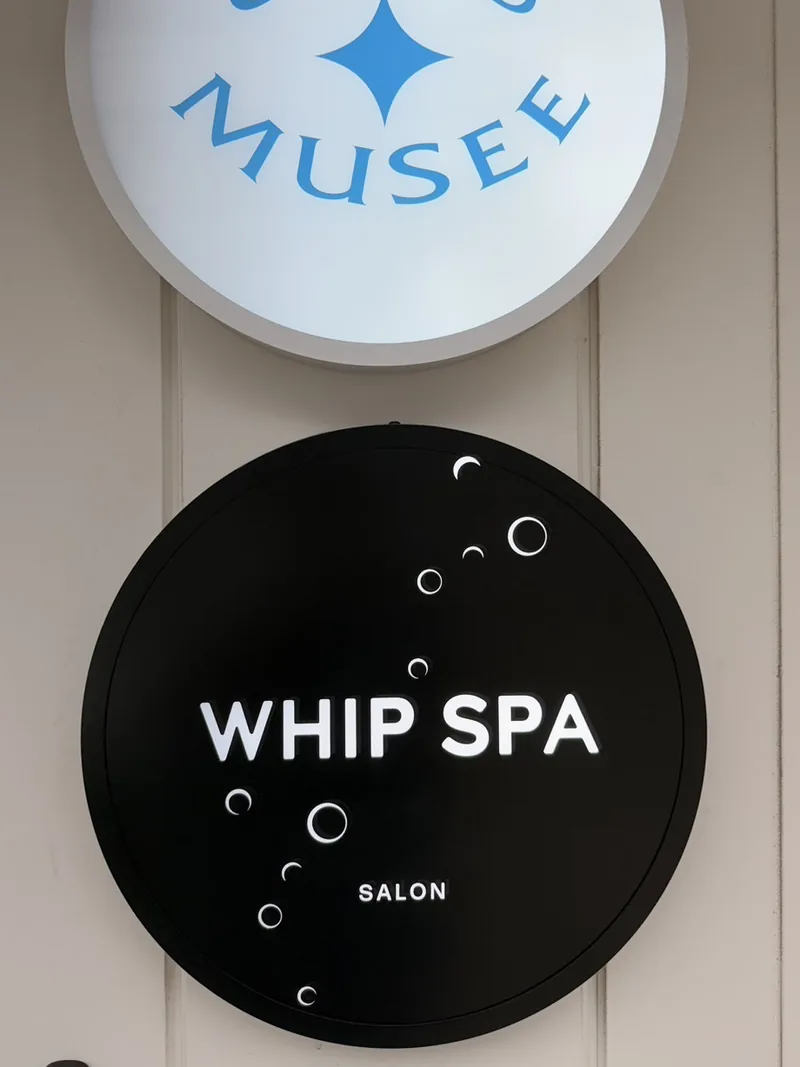 入口の横にある WHIP SPA の丸い看板